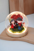 Crimson Love crystal ball with couple miniatures in round glass dome, LED warm lighting on, blank customisable signboard and wooden base