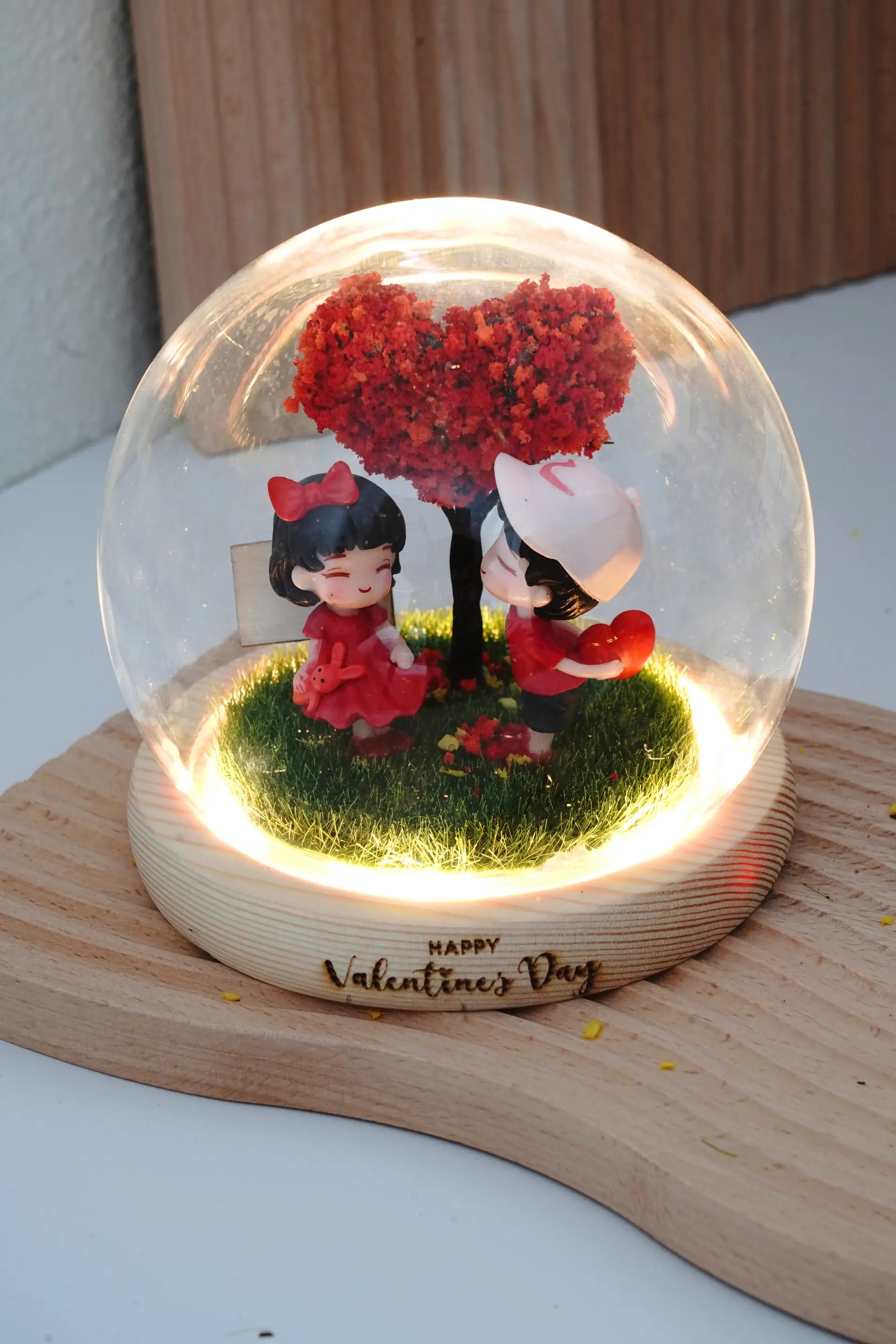Valentine's crystal ball with couple miniatures in round glass dome, LED warm lighting on, blank customisable signboard and engraved wooden base